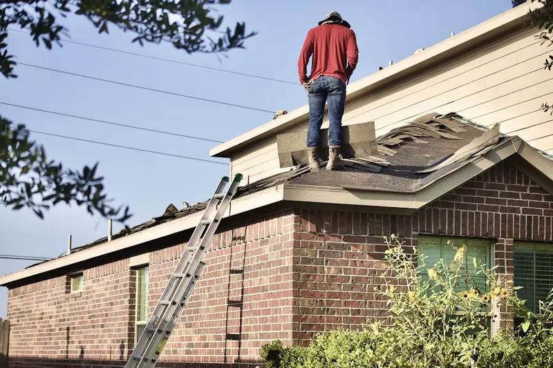 Professional roofer working on a residential roof in Arlingham
